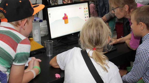 Kinder arbeiten an einem Computer mit einer 3D-Modellierungssoftware.