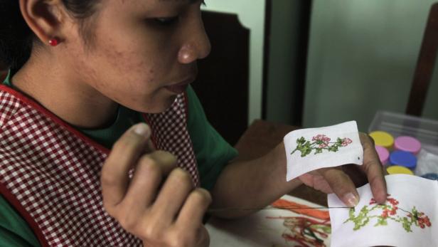 A student worker creates cross stitch designs for greeting cards at the Good Shepherd convent in Baguio city, northern Philippines March 2, 2013. Some 400 youths, mostly girls, are employed by nuns in the convent for the production of famous delicacies and handicrafts from northern Philippines, with proceeds from the sales going towards the youths&#039; education and activities organized by the convent to inculcate good values in them, according to a nun. Picture taken March 2, 2013. REUTERS/Erik De Castro (PHILIPPINES - Tags: RELIGION EDUCATION SOCIETY)