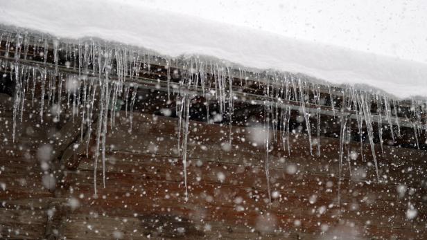 APA10536464 - 06122012 - HOCHFILZEN - ÖSTERREICH: THEMENBILD - Blick durch dichten Schneefall auf Eiszapfen an einer Dachrinne, am Donnerstag, 6. Dezember 2012, im Gebiet von Hochfilzen APA-FOTO: BARBARA GINDL