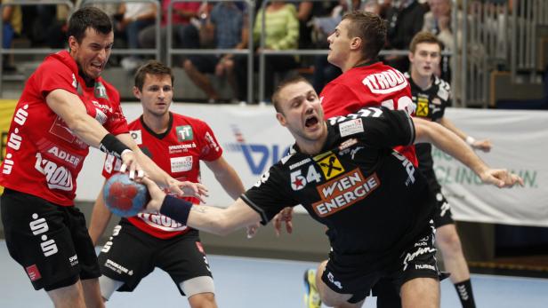 Handballspieler kämpfen um den Ball während eines Spiels.