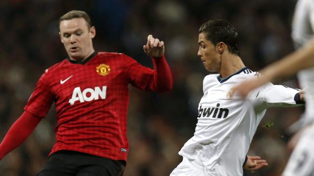 epa03582468 Real Madrid&#039;s Portuguese Cristiano Ronaldo (R) fights for the ball with Manchester United&#039;s Wayne Rooney (C) during the UEFA Champions League round of 16 first leg match between Real Madrid and Manchester United at Santiago Bernabeu stadium in Madrid, Spain, 13 February 2013. EPA/JAVIER LIZON