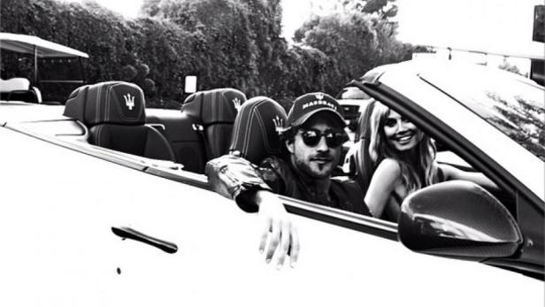 Ein Mann und eine Frau sitzen in einem weißen Maserati-Cabriolet.
