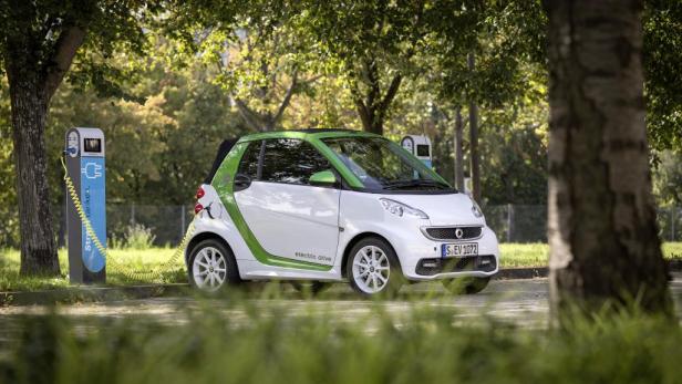 Ein weißer Smart „electric drive“ wird an einer Stromtankstelle aufgeladen.