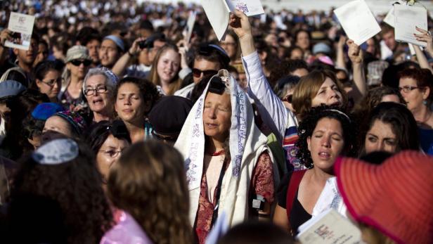 epa03694190 Women of the Wall members, wearing their prayer shawls pray during their monthly prayer at the beginning of a new Jewish month, at the Western Wall compound in Jerusalem, Israel, 10 May 2013. Thousands of ultra-Orthodox Jewish men and women came to protest against the prayers of the Women of the Wall group. EPA/ABIR SULTAN