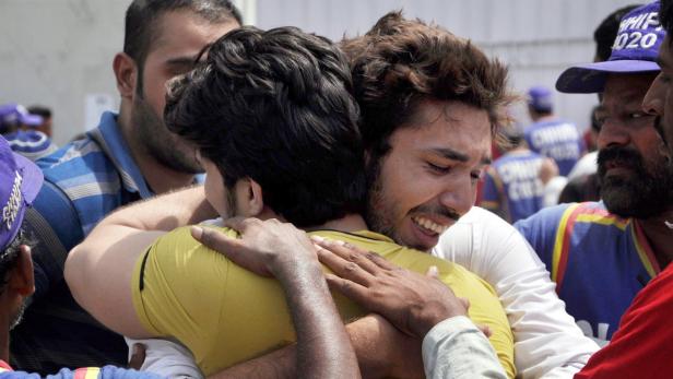 epa03695699 Rescue workers comfort the relatives of the victims of a bomb blast in restive Karachi, Sindh province, Pakistan, 11 May 2013. At least 11 persons were killed and dozens injured in the incident. Millions of voters began casting their ballots 11 May, in Pakistanís key general elections after a campaign marked by violence. The nationwide vote marks the first time a civilian government would transfer power to an elected successor after completing a full five-year term. EPA/SHAHZAIB AKBER