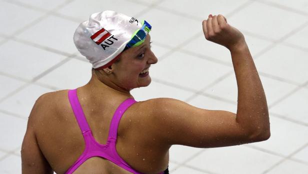 Eine österreichische Schwimmerin jubelt mit erhobener Faust.