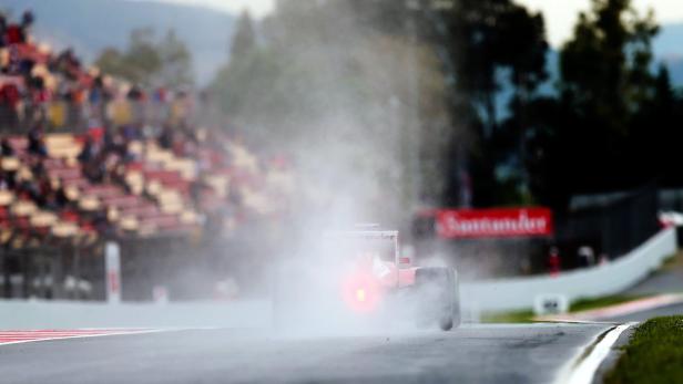 Ein Formel-1-Rennwagen fährt bei Regen auf einer Rennstrecke.