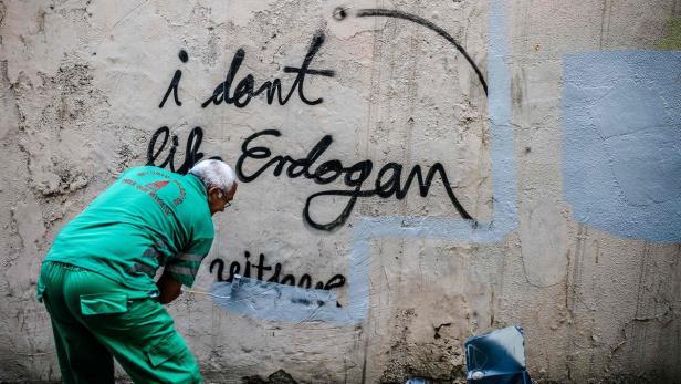 Ein Mitarbeiter der Stadt Istanbul entfernt ein kritisches Graffito