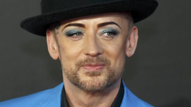 Porträt von Boy George mit Hut und blauem Blazer.