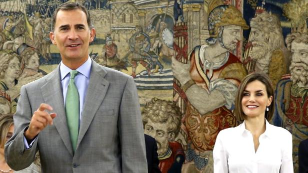 König Felipe VI. und Königin Letizia vor einem Wandteppich.