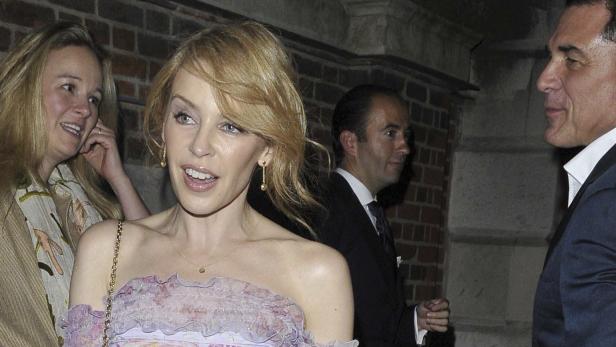Kylie Minogue bei einer Veranstaltung mit anderen Gästen.
