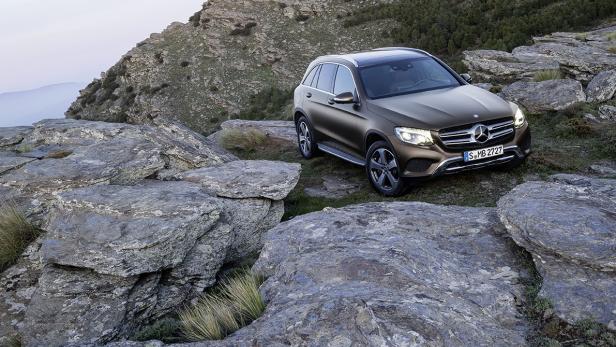 Ein bronzefarbener Mercedes-Benz GLC steht auf einem felsigen Hügel.