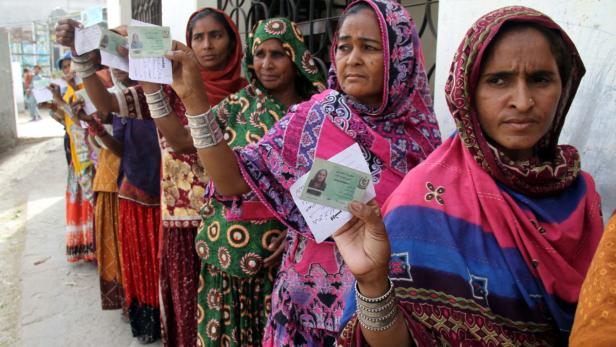 epa03695730 Pakistani women display their national identity cards as they wait to cast their ballots in Tando Jam, Sindh province, Pakistan, 11 May 2013. Millions of voters began casting their ballots 11 May, in Pakistanís key general elections after a campaign marked by violence. The nationwide vote marks the first time a civilian government would transfer power to an elected successor after completing a full five-year term. EPA/NADEEM KHAWER