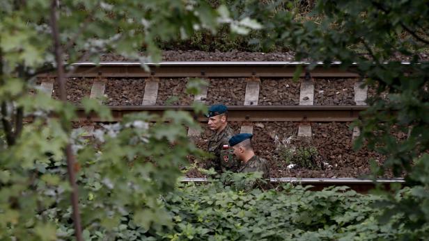 Zwei polnische Soldaten stehen in der Nähe eines Bahngleises.