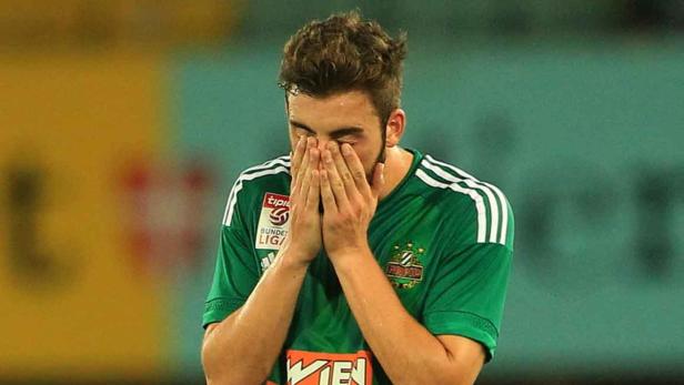 Fussball , Rapid - Mattersburg Ein Fußballspieler in Grün verdeckt sein Gesicht mit den Händen.