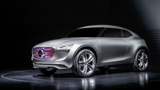 Ein silberfarbenes Mercedes-Benz Concept Coupé SUV mit einem lila Kühlergrill steht auf einer Bühne.