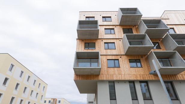 Ein modernes Mehrfamilienhaus mit Holzelementen und kubischen Balkonen.