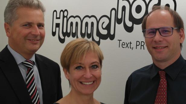 Drei Personen posieren vor dem Logo von „Himmelhoch Text, PR“.