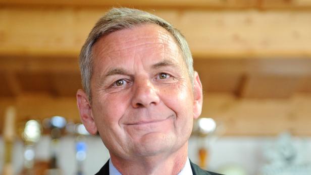 Porträt eines lächelnden Mannes mit kurzem, grauem Haar.