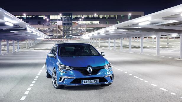 Ein blauer Renault Mégane steht auf einem Parkplatz bei Nacht.