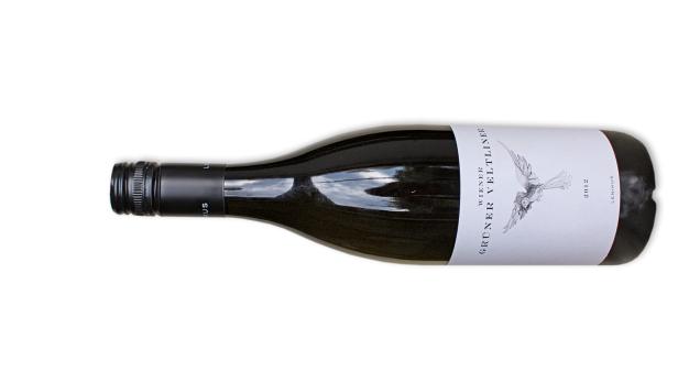 Eine Flasche Wiener Grüner Veltliner Lenikus 2012 liegt auf einer weißen Oberfläche.