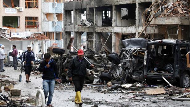 Officials work on one of the sites of the twin car bomb attacks in the town of Reyhanli of Hatay province near the Turkish-Syrian border May 12, 2013. Twin car bombs killed 43 people and wounded many more in a Turkish town near the Syrian border on Saturday and the government said it suspected Syrian involvement. The bombing increased fears that Syria&#039;s civil war was dragging in neighbouring states despite renewed diplomatic moves towards ending two years of fighting in which more than 70,000 people have been killed. The bombs ripped into crowded streets near Reyhanli&#039;s shopping district in the early afternoon, scattering concrete blocks and smashing cars in the town in Turkey&#039;s southern Hatay province, home to thousands of Syrian refugees. REUTERS/Umit Bektas (TURKEY - Tags: POLITICS CIVIL UNREST)