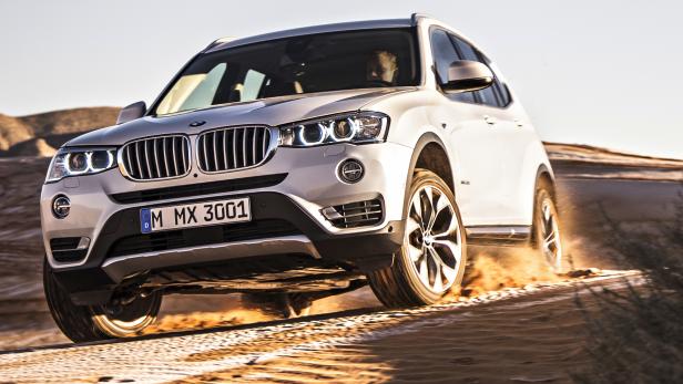 Ein weißer BMW X3 fährt durch eine sandige Landschaft.