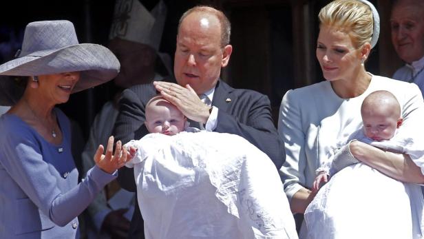 Princess Caroline of Hanover protects the head of Fürst Albert und Fürstin Charlène von Monaco mit ihren Zwillingen bei einer Taufe.