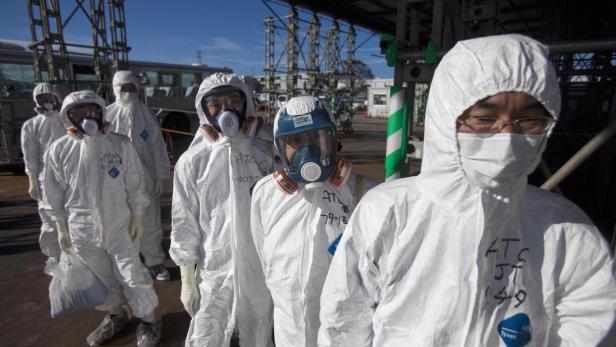 File photo of workers in protective suits and mask