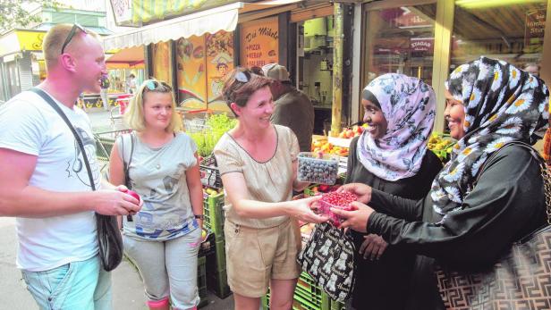 Isida Kristo (Mitte) hilft Flüchtlingen beim Deutschlernen.