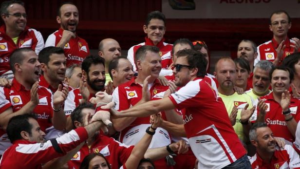 Ferrari Formula One driver Fernando Alonso of Spain (R) celebrates with his team after the Spanish F1 Grand Prix at the Circuit de Catalunya in Montmelo, near Barcelona, May 12, 2013. REUTERS/Sergio Perez (SPAIN - Tags: SPORT MOTORSPORT F1)