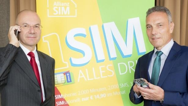 Zwei Männer präsentieren eine „Allianz SIM“-Karte und ein Smartphone vor einem Werbebanner.