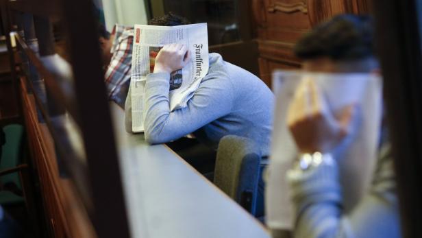 Ein Mann versteckt sein Gesicht hinter einer Zeitung mit dem Titel „Frankfurter“.