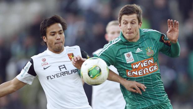 Zwei Fußballspieler kämpfen um den Ball während eines Spiels.
