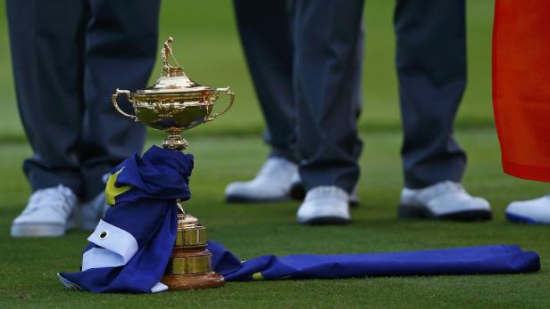 Die Ryder-Cup-Trophäe mit einer Europaflagge auf einem Golfplatz.