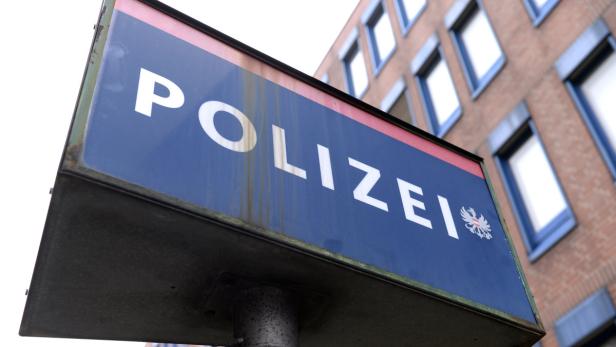 Ein Schild mit der Aufschrift „Polizei“ vor einem Gebäude.