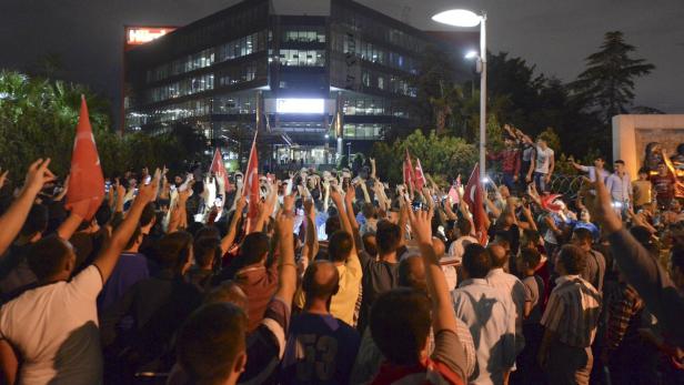 Eine Menschenmenge mit türkischen Flaggen demonstriert vor einem Gebäude.