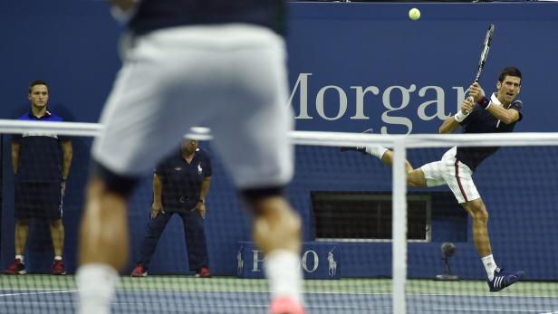 Novak Đoković schlägt einen Ball während eines Tennisspiels.