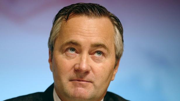 Porträt eines Mannes mit grau meliertem Haar, der nach oben links blickt.