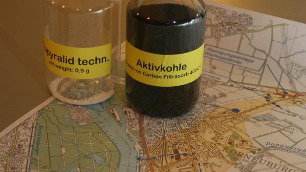 Zwei Behälter mit Pyralid und Aktivkohle stehen auf einer Landkarte von Korneuburg.