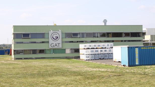 Das GAT-Gebäude mit Containern und gestapelten IBC-Containern im Außenbereich.