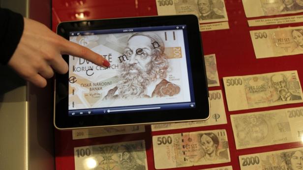 Eine Person betrachtet auf einem Tablet eine 200-Kronen-Banknote mit Jan Amos Komenský.