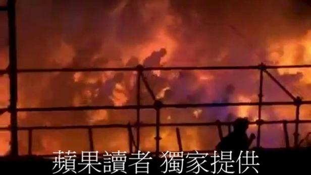 Ein Gebäude steht in Flammen, Rauch steigt auf.