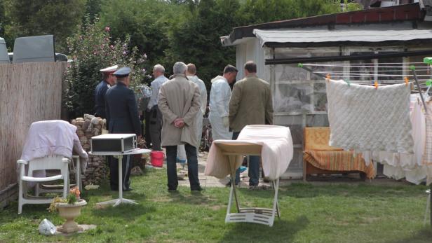 Polizei und Spurensicherung arbeiten in einem Garten.