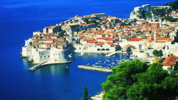 Blick auf die Altstadt von Dubrovnik mit ihren roten Dächern und dem blauen Meer.