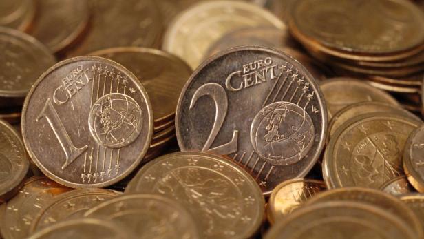 Inmitten eines riesigen Münzberges leuchten am Dienstag (24.08.2004) in Frankfurt am Main eine Ein- und eine Zwei-Cent-Münze (Illustrationsbild). Die Deutschen wollen nach einer Umfrage mehrheitlich auf die kleinen Cent-Münzen nicht verzichten. 54 Prozent sprachen sich dagegen aus, die Ein- und Zwei-Cent-Münzen abzuschaffen, ergab eine repräsentative Umfrage des Forschungsinstituts Emnid im Aufrag der &quot;Wirtschaftswoche&quot;. Für einen Verzicht wie in den Niederlanden oder in Finnland - wo die Händler die Cent-Beträge auf- oder abrunden - plädierten 39 Prozent der Befragten. Emnid hatte am vergangenen Wochenende 1000 Bundesbürger im Alter ab 16 Jahren befragt. Foto: Boris Roessler dpa/lhe