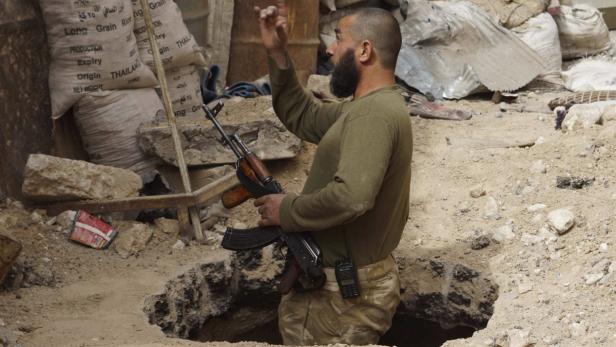 A member of the Free Syrian Army speaks while standing in a hole in the ground, in Deir al-Zor April 2, 2013. Picture taken April 2, 2013. REUTERS/ Khalil Ashawi (SYRIA - Tags: POLITICS CIVIL UNREST )