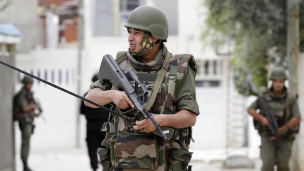 Ein Soldat in Kampfmontur patrouilliert in einer städtischen Umgebung.