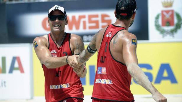 Zwei Beachvolleyballspieler aus Österreich geben sich die Hand nach einem Spiel.