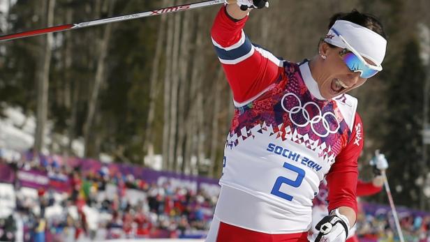 Norway's Bjoergen celebrates crossing the finish l